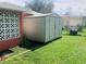 Backyard featuring green grass, a small shed for storage and a privacy fence at 22032 Felton Ave, Port Charlotte, FL 33952