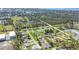 Expansive aerial view of a residential community with lush green lawns, mature trees, and a serene lake nearby at 224 Pine Glen Ct, Englewood, FL 34223
