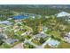 Aerial shot of a property showcasing its neatly landscaped yard, serene pond, and proximity to lush greenery at 224 Pine Glen Ct, Englewood, FL 34223