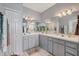 Bright bathroom featuring double sinks, a large mirror, neutral countertops, and a closet at 224 Pine Glen Ct, Englewood, FL 34223