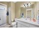 Neutral bathroom featuring white vanity, toilet, shower, and decorative wall lighting at 224 Pine Glen Ct, Englewood, FL 34223