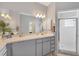Well-lit bathroom with a vanity, a large mirror, and a glass-enclosed shower at 224 Pine Glen Ct, Englewood, FL 34223