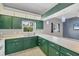 Traditional kitchen with green cabinets, white countertops and a view to the living room at 224 Pine Glen Ct, Englewood, FL 34223