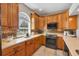 Bright kitchen featuring wooden cabinetry, modern appliances, and a large window for ample natural light at 224 Pine Glen Ct, Englewood, FL 34223