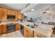 Open kitchen with wooden cabinets, stainless steel appliances, breakfast bar, and open view to the living area at 224 Pine Glen Ct, Englewood, FL 34223