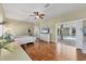 Bright main bedroom with hard floors, a ceiling fan, an attached office, and a view to the pool area at 224 Pine Glen Ct, Englewood, FL 34223