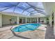 Beautiful pool with a screened enclosure, tile patio, and multiple access points to the home at 224 Pine Glen Ct, Englewood, FL 34223