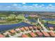 Overhead view of homes in a golf community surrounded by lakes, palm trees, and a lush golf course at 23781 Waverly Cir, Venice, FL 34293