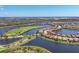 A broad aerial shot showcasing a neighborhood with golf course, and lake views at 23781 Waverly Cir, Venice, FL 34293