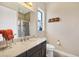 Well-lit bathroom features a glass-enclosed shower, granite countertop and modern fixtures at 23781 Waverly Cir, Venice, FL 34293
