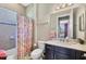 Tiled bathroom with shower/tub combo, featuring a decorative shower curtain and modern vanity at 23781 Waverly Cir, Venice, FL 34293