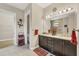 Bathroom with double vanity, dark cabinets, and a view of the shower at 23781 Waverly Cir, Venice, FL 34293