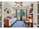 Bedroom with a daybed and desk, featuring a ceiling fan and ample natural light at 23781 Waverly Cir, Venice, FL 34293