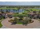Elegant 'Sarasota National' entrance featuring lush landscaping, palm trees, and beautifully designed architecture at 23781 Waverly Cir, Venice, FL 34293