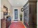 Inviting foyer with elegant furnishings, a decorative mirror, stylish lamps, and a patterned red rug at 23781 Waverly Cir, Venice, FL 34293