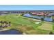 An aerial view of a lush golf course winding through a community, complemented by mature trees and a pond at 23781 Waverly Cir, Venice, FL 34293