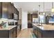 Modern kitchen featuring dark cabinets, stainless steel appliances, and granite countertops at 23781 Waverly Cir, Venice, FL 34293