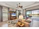 Cozy living room with plush seating, a ceiling fan, and views of the serene lake and patio at 23781 Waverly Cir, Venice, FL 34293