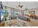 Spacious living room features comfortable seating, ceiling fans, and seamless access to an outdoor patio and lake views at 23781 Waverly Cir, Venice, FL 34293