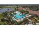 Stunning aerial view of a community pool featuring lush landscaping, lounge chairs and umbrellas at 23781 Waverly Cir, Venice, FL 34293