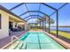Spacious screened in pool with outdoor dining and lounging area with a lake view at 23781 Waverly Cir, Venice, FL 34293