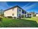 The backyard features green grass and a view of neighboring condo buildings at 409 Pine Hollow Cir # 409, Englewood, FL 34223