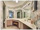 Beautiful bathroom featuring dual vanities, ample counter space, decorative wallpaper, and large mirrors at 409 Pine Hollow Cir # 409, Englewood, FL 34223