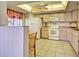 Functional kitchen with white appliances, tile flooring, a breakfast bar, and ample cabinet space at 409 Pine Hollow Cir # 409, Englewood, FL 34223