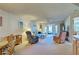 Bright living room with access to the balcony, comfortable seating, and neutral carpet at 409 Pine Hollow Cir # 409, Englewood, FL 34223
