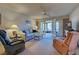 Cozy living room with comfortable seating, ceiling fan, and French doors to lanai at 409 Pine Hollow Cir # 409, Englewood, FL 34223