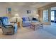 Bright living room with a sofa, recliner, and French doors to the lanai at 409 Pine Hollow Cir # 409, Englewood, FL 34223