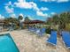 Inviting poolside with lounge chairs, a pergola and lush tropical foliage at 409 Pine Hollow Cir # 409, Englewood, FL 34223