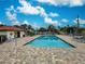 Resort-style swimming pool with a brick deck, cabana, lounge chairs and blue skies at 409 Pine Hollow Cir # 409, Englewood, FL 34223