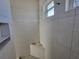 Shower stall with white textured wall tiles and a small window above a built-in shelf at 418 Rotonda Cir, Rotonda West, FL 33947