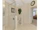 Tiled bathroom featuring glass enclosed shower, toilet, and an archway leading to the bedroom at 4624 Club Dr # G201, Port Charlotte, FL 33953