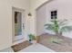 Charming front porch featuring a decorative door, small window, lantern, and manicured plants at 4624 Club Dr # G201, Port Charlotte, FL 33953