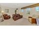 Spacious living room with brown leather sofa and chairs, windows with valances, and neutral carpet at 4624 Club Dr # G201, Port Charlotte, FL 33953