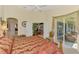 Bright and airy main bedroom with light-colored walls, ceiling fan, and sliding doors to a sunroom at 4624 Club Dr # G201, Port Charlotte, FL 33953