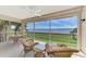 Relaxing screened patio offers tranquil water views and comfortable wicker furniture and ceiling fan at 4624 Club Dr # G201, Port Charlotte, FL 33953