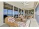 Relaxing screened patio offers tranquil water views and comfortable wicker furniture and ceiling fan at 4624 Club Dr # G201, Port Charlotte, FL 33953