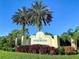 Riverwood community sign, a deed-restricted community, with manicured landscaping and two palm trees against a bright blue sky at 4697 Club Dr # 201, Port Charlotte, FL 33953