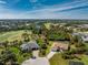 Aerial view of property featuring a manicured lawn and surrounding landscaping, near a golf course and lake at 48 Par View Ct, Rotonda West, FL 33947