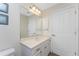 Bright bathroom with a white vanity, large mirror with lighting, and a tiled floor at 48 Par View Ct, Rotonda West, FL 33947