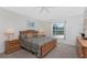 Bedroom with a window overlooking the patio, carpet, and a wooden dresser with lamps at 48 Par View Ct, Rotonda West, FL 33947