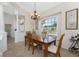 Well-lit dining area with tile floors, a wooden table set, and a view to the front yard at 48 Par View Ct, Rotonda West, FL 33947