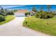 Single-story home with a manicured lawn and long driveway, offering a welcoming curb appeal at 48 Par View Ct, Rotonda West, FL 33947