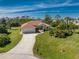 Aerial view of a well-maintained home with a long driveway and lush landscaping in a peaceful neighborhood at 48 Par View Ct, Rotonda West, FL 33947