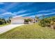 Charming single-story home with a well-manicured lawn, palm trees, and a two-car garage at 48 Par View Ct, Rotonda West, FL 33947