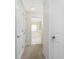 Bright hallway leads to the bathroom, featuring white doors and neutral carpet at 48 Par View Ct, Rotonda West, FL 33947
