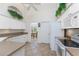 Bright kitchen with white cabinets, tile flooring, and view into dining room at 48 Par View Ct, Rotonda West, FL 33947